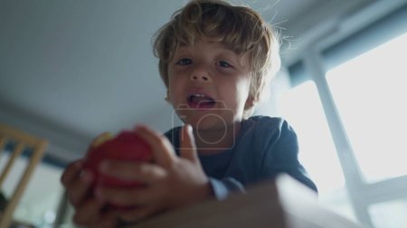 Photo for Little boy eating apple fruit child eats healthy snack - Royalty Free Image