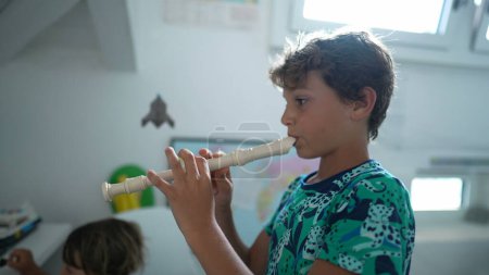 Téléchargez les photos : Enfant jouer de la flûte jeune garçon joue de l'instrument de musique - en image libre de droit