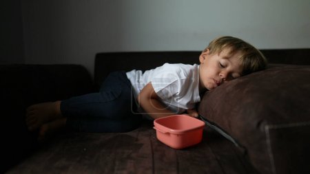 Photo for One pnesive toddler lying in sofa resting snacking food - Royalty Free Image