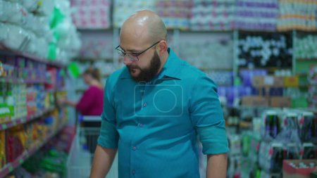 Photo for Customer looking at products in supermarket aisle. Person shopping, consumer lifestyle - Royalty Free Image