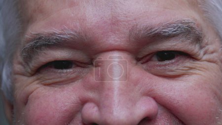 Foto de Macro apretado primer plano de hombre maduro mayor sonriendo. Feliz anciano hombre en los años 70 con arrugas mirando intensamente a la cámara - Imagen libre de derechos
