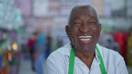 Téléchargez les photos : Joyeux employé afro-américain senior du magasin local, souriant à la caméra - en image libre de droit
