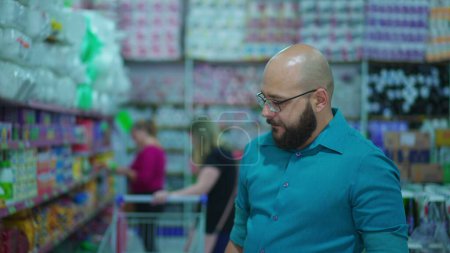 Foto de Cliente mirando los productos en el pasillo del supermercado. Compras de personas, estilo de vida del consumidor - Imagen libre de derechos