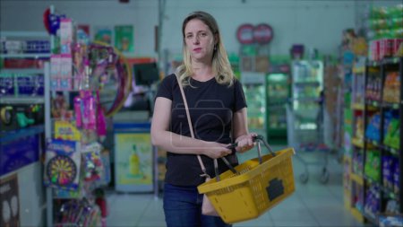 Foto de Mujer caucásica seria en el supermercado durante tiempos difíciles, hábitos de estilo de vida de consumismo - Imagen libre de derechos