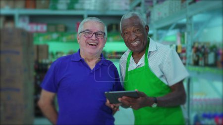 Foto de Alegre senior diversos colegas de supermercado sonriendo a la cámara. Dos gerentes de personal de más edad del supermercado en el pasillo - Imagen libre de derechos