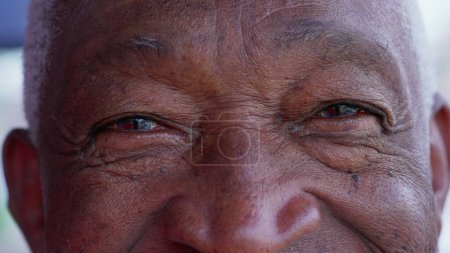 Foto de Macro primer plano de una persona mayor feliz carismático ancianos ojos mirando a la cámara sonriendo con emoción amistosa que representa la sabiduría y la vejez con arrugas - Imagen libre de derechos