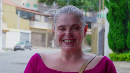 Téléchargez les photos : Mature visage décontracté heureux portrait de femme debout dans la rue avec expression souriante joyeuse. 50 femme caucasienne personne - en image libre de droit