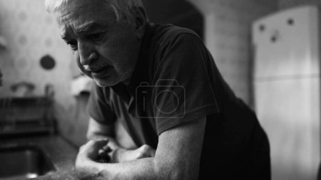 Photo for Dramatic senior in despair struggling with mental illness at home in monochrome, black and white. Older person suffering alone in desperation - Royalty Free Image
