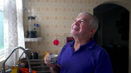 Téléchargez les photos : Homme âgé savourant le café du matin, moment paisible par la fenêtre de la maison - en image libre de droit
