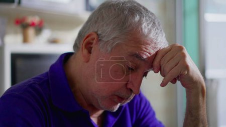 Photo for Hopeless senior man struggling with depression alone at home. Close-up face of an older person in quiet despair, melancholic and mental illness depiction - Royalty Free Image