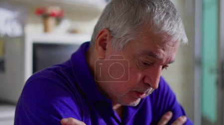 Photo for Hopeless senior man struggling with depression alone at home. Close-up face of an older person in quiet despair, melancholic and mental illness depiction - Royalty Free Image