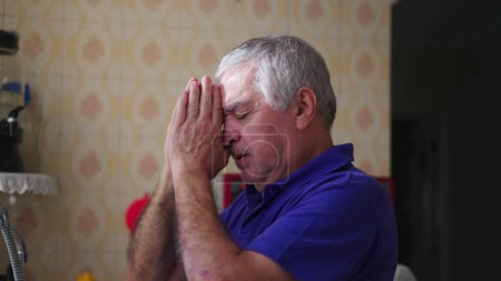 Téléchargez les photos : Elderly Man in Hopeful Prayer, Seeking Solace through Faith at Home. Personne âgée dévouée dans la prière méditative, embrassant la foi dans les moments difficiles - en image libre de droit