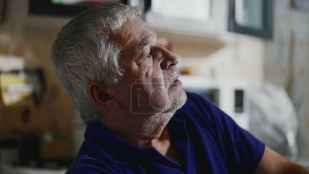 Photo for Sad depressed unshaven senior lost in thought at home staring out home window in quiet despair - Royalty Free Image