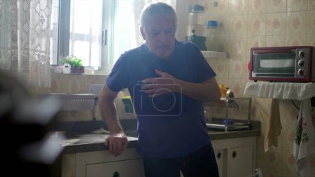 Foto de Hombre mayor caucásico en extrema necesidad de ayuda médica, colapsando de un ataque al corazón solo en casa por fregadero de cocina - Imagen libre de derechos