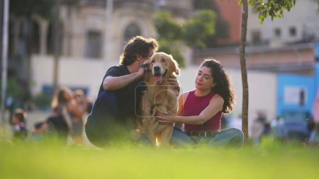 Téléchargez les photos : Joyeux couple au parc avec leur compagnon de chien. Une escapade week-end avec une belle Golden Retriever dans la nature - en image libre de droit
