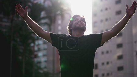 Photo for One young Religious Man looking up at the sky with HOPE and FAITH. A happy male caucasian person feeling GRATEFUL putting hand in CHEST - Royalty Free Image