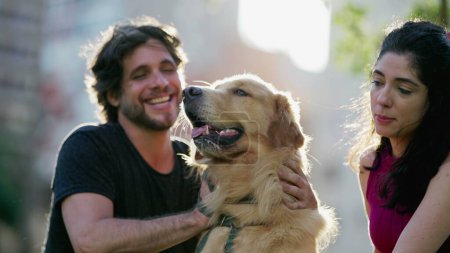 Téléchargez les photos : Couple franc avec leur Golden Retriver Pet Dog à l'extérieur au parc. Chien aboyant à la caméra - en image libre de droit