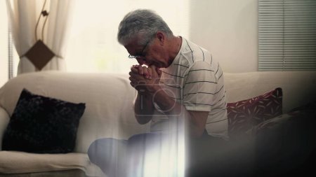 Téléchargez les photos : Anxieux homme âgé névrotique lutte contre la préoccupation et l'inquiétude à la maison seul. Désespoir silencieux dans le concept de vieillesse, souffrant de maladie mentale et du processus de vieillissement - en image libre de droit