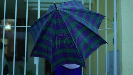 Photo for Senior Man Opens Gate, Steps out from Home with Umbrella in the Rain, Walks on Urban Sidewalk - Royalty Free Image