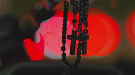 Photo for Rainy Night Drive with Christian Cross Hanging in Vehicle Windshield - Royalty Free Image