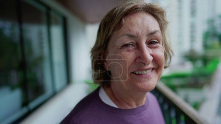 Téléchargez les photos : Portrait d'une heureuse femme âgée souriant à la caméra. Une femme dans les années 70 souriant à la caméra gros plan visage - en image libre de droit