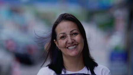 Foto de Mujer brasileña feliz retrato cara de cerca de pie en la calle mirando a la cámara sonriendo. Auténticas personas de la vida real - Imagen libre de derechos