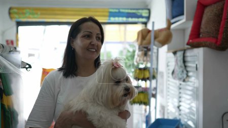 Téléchargez les photos : Pet Shop Shopping, Femme avec petit chien examinant articles de magasin - en image libre de droit