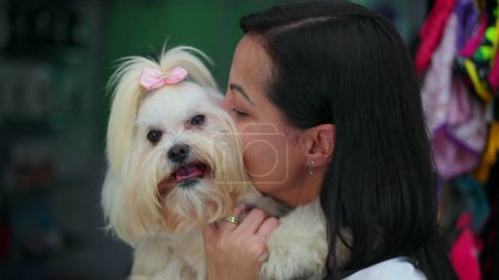 Foto de Mujer feliz abrazando a su perrito. Momento cándido de afecto canino y cuidado de la raza Shih-Tzu - Imagen libre de derechos