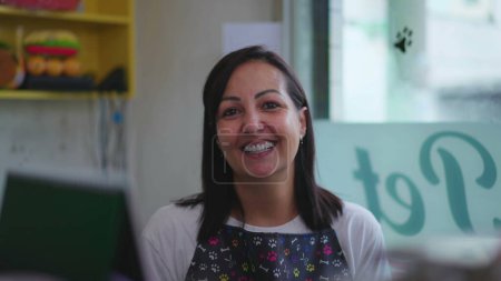 Téléchargez les photos : Portrait d'une femme entrepreneure heureuse propriétaire d'une petite entreprise derrière le comptoir portant tablier - en image libre de droit
