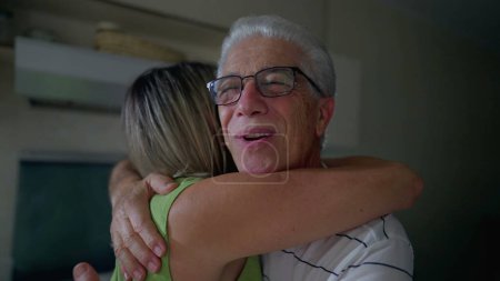 Photo for Older friend happy reunion. Middle-age woman hugging senior man in kitchen. People authentic embrace - Royalty Free Image