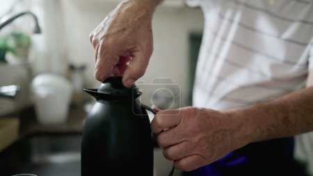 Photo for Close-up hand tightening and loosening thermos bottle preparing warm drink, coffee or tea - Royalty Free Image