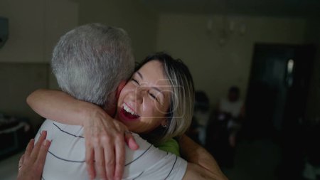 Téléchargez les photos : Joyeuses retrouvailles entre amis seniors. Homme plus âgé embrassant femme d'âge moyen, embrassade joyeuse entre les gens - en image libre de droit