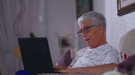 Foto de Hombre mayor preocupado frente a la computadora portátil con expresión frustrada preocupado. Personas mayores de cabello gris que sienten estrés y ansiedad por los resultados negativos mientras usan la tecnología - Imagen libre de derechos