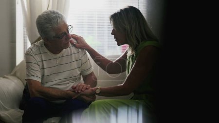 Téléchargez les photos : Homme âgé en conversation franche avec un partenaire de soutien, aux prises avec des moments difficiles à la maison - en image libre de droit