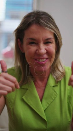 Photo for Mature woman talking to webcam participating in video-conference speaking with family relatives, Video call in Vertical Video - Royalty Free Image