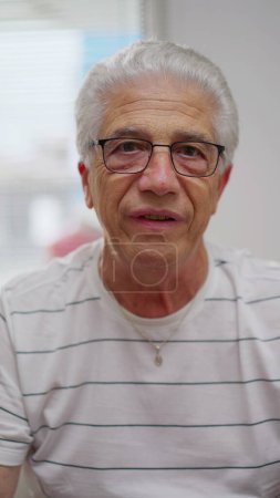 Téléchargez les photos : Homme âgé participant à une vidéoconférence avec sa famille, Vidéo verticale de grand-père parlant à Webcam POV - en image libre de droit