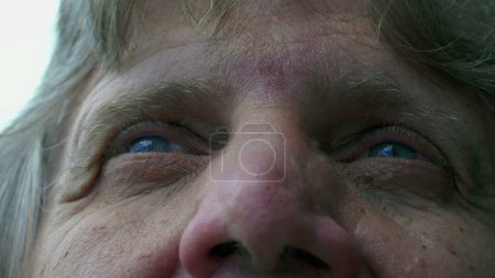 Téléchargez les photos : Homme âgé fidèle aux yeux bleus regardant vers le ciel, affichant sagesse et âge - en image libre de droit