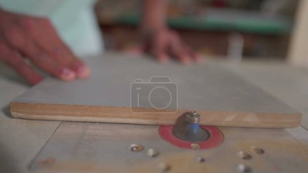 Photo for Close-up of machine trimming side of piece of wood in carpentry workshop - Royalty Free Image