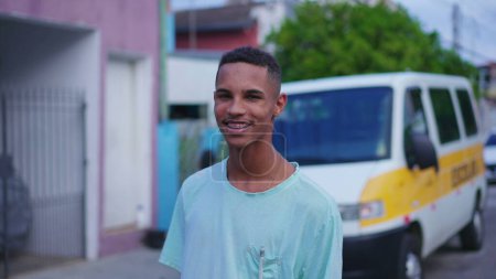 Foto de Un joven brasileño negro alegre parado en la calle sonriendo a la cámara. 20s individuo de América del Sur, personas auténticas de la vida real - Imagen libre de derechos