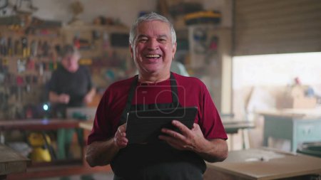 Téléchargez les photos : Portrait de charpentier sénior heureux supervisant des affaires avec la tablette - en image libre de droit