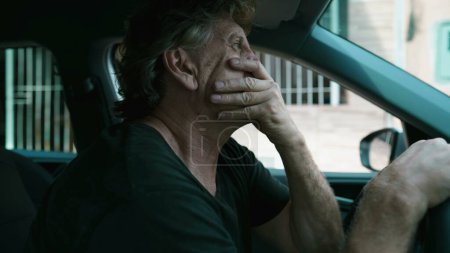 Photo for One pensive senior man pondering decision while parked in street gripping vehicle steering wheel during times of stress. Contemplative pensive older caucasian person - Royalty Free Image