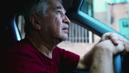 Photo for Desperate senior man gazing upwards at sky asking for God's help during hard times, sitting inside car, parked in street. Struggling older person in emotional pain - Royalty Free Image