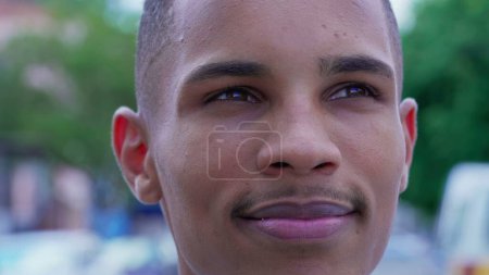 Photo for One Happy Black Young Man gazing upwards at sky smiling with HOPE and FAITH. Close-up face of a joyful Brazilian person feeling gratitude - Royalty Free Image