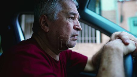 Photo for Desperate senior man gazing upwards at sky asking for God's help during hard times, sitting inside car, parked in street. Struggling older person in emotional pain - Royalty Free Image