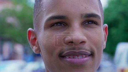 Photo for One Happy Black Young Man gazing upwards at sky smiling with HOPE and FAITH. Close-up face of a joyful Brazilian person feeling gratitude - Royalty Free Image