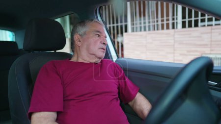 Photo for Senior man struggling with life's difficulties standing inside vehicle parked in street. Preoccupied Elderly person suffering from anxiety - Royalty Free Image