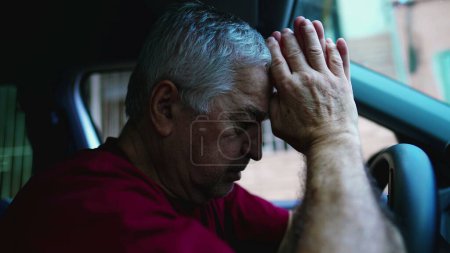 Téléchargez les photos : Vieil homme religieux priant Dieu pendant les moments difficiles assis à l'intérieur du véhicule, garé dans la rue regardant le ciel demandant de l'aide divine - en image libre de droit
