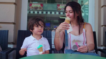 Téléchargez les photos : Partage Moments scène de mère laissant l'enfant échantillon de sa saveur de crème glacée d'été - en image libre de droit