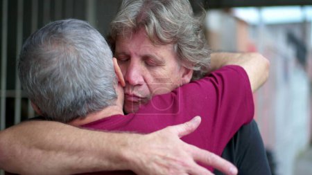Photo for Heart-warming embrace between two senior friends in authentic loving hug. Two elderly people saying farewell embracing, candid and real life family affection - Royalty Free Image