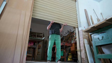 Foto de Propietario local de negocios abriendo tienda, puerta corredera del garaje de la tienda de carpintería - Imagen libre de derechos